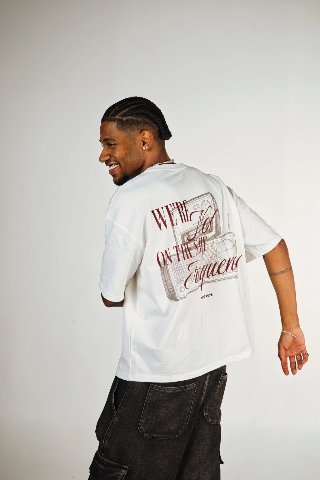 Man wearing a white t-shirt with text and graphics on the back, standing against a plain background.