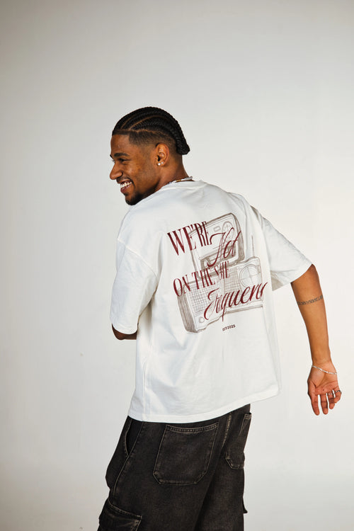 Man wearing a white t-shirt with text and graphics on the back, standing against a plain background.
