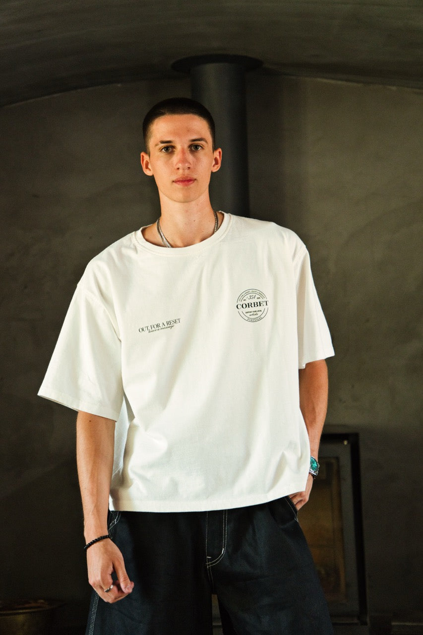 Person wearing a white t-shirt with text and graphics against a dark background