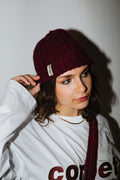 Girl wearing red wine crochet beanie with a matching longsleeve and crochet crossbody handmade bag